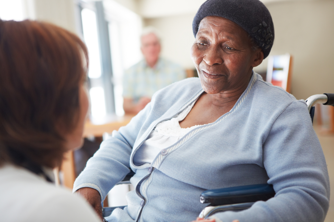 an older black woman in a wheelchair speaking with a doctor